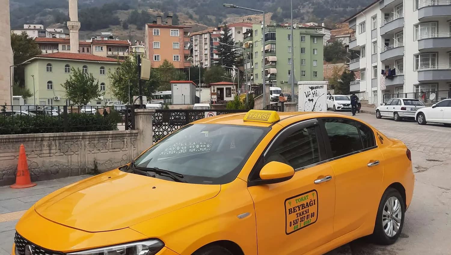 Tokat'ta cami ve dağ manzarası önünde Beybağı Taksi aracı